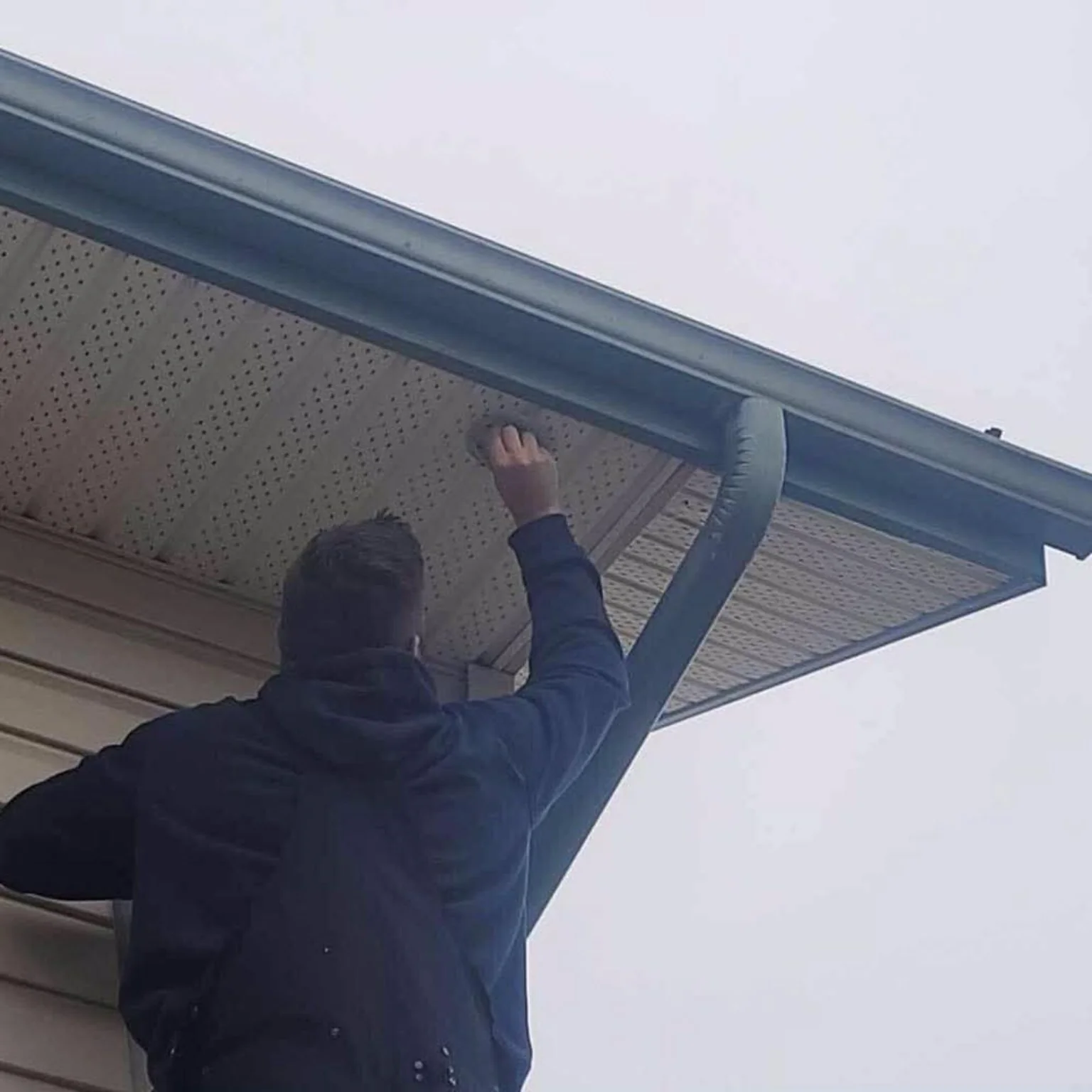 Ready Tech installer routing a security camera cable through a residential soffit